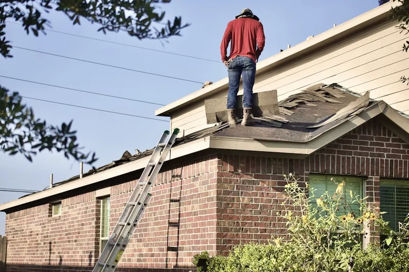 Professional roofer working on a residential roof in Village Builders